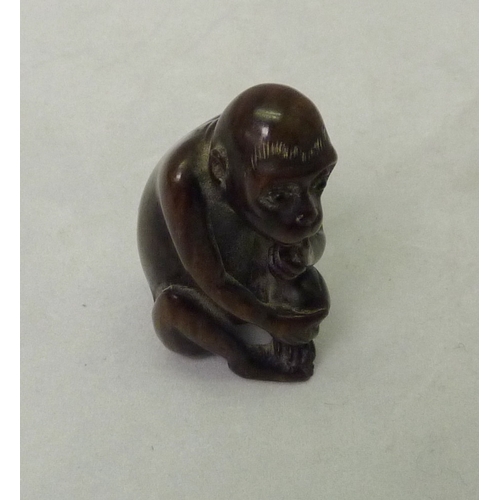 393 - An okimono depicting a seated monkey, carved hardwood, 50mm tall