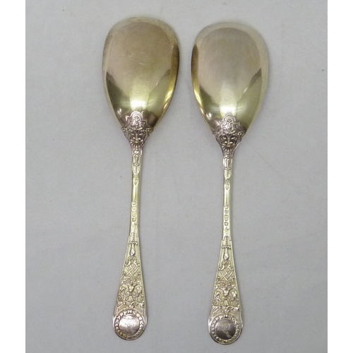 431 - A pair of Victorian silver serving spoons decorated with a registered cast Jacobethan design incorpo... 