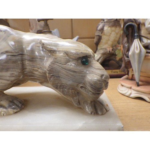 46 - An oak cased mantel clock; a carved resin leopard figure on a onyx base; various figurines.