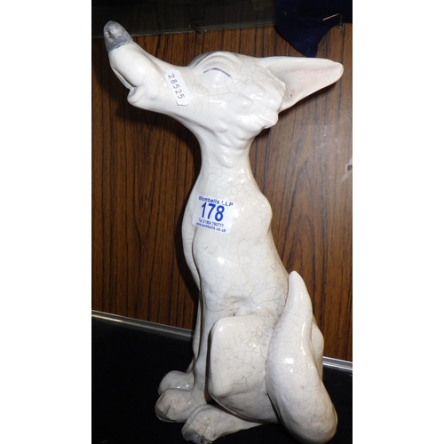 178 - A ceramic dog, indistinctly signed John H....  ? 33cm tall.