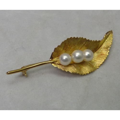 362 - A leaf brooch set with three pearls.  Yellow metal marked k18.  56mm long.