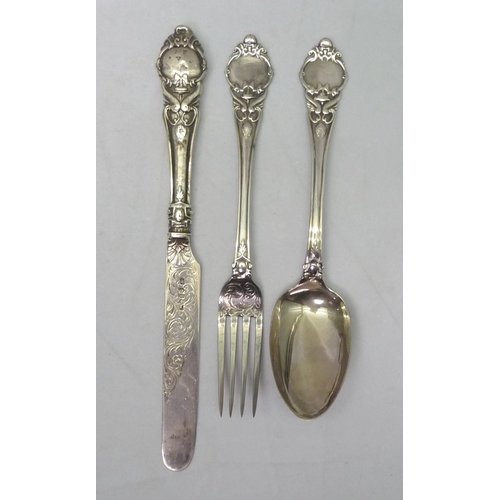 372 - A silver knife fork & spoon set; a pierced silver dish, a silver topped glass jar; silver plated cut... 