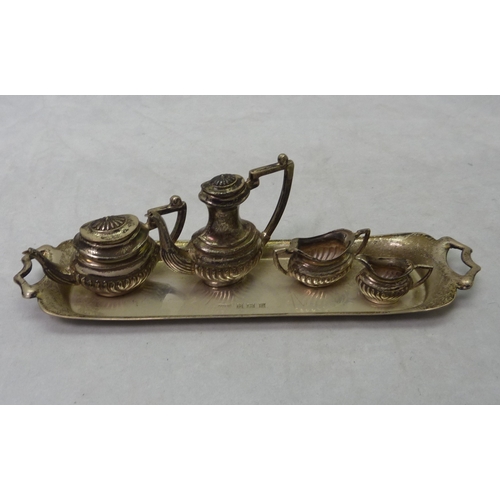 387 - A miniature four piece tea set on a matching silver tray, 20th cent.  Tray 148mm long / 30gr