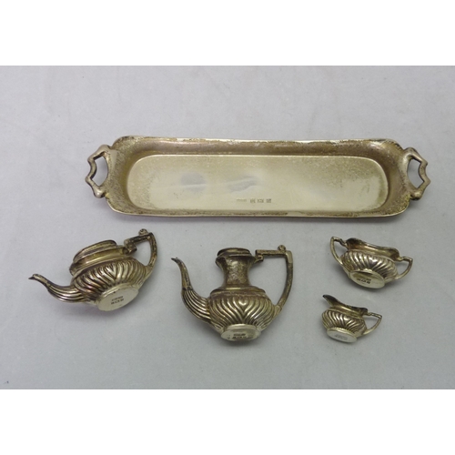 387 - A miniature four piece tea set on a matching silver tray, 20th cent.  Tray 148mm long / 30gr