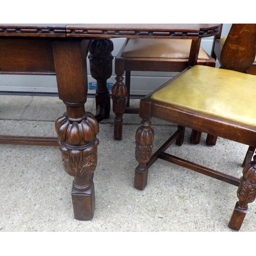 608 - A 1930's carved oak draw leaf table and six chairs, incl  one carver