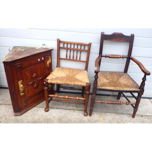 706 - An oak hanging corner cupboard together with two provincial rush seated chairs (3)