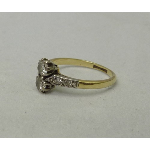 407 - A ring, yellow metal set with two brilliant cut diamonds with four further small diamonds in the sho... 