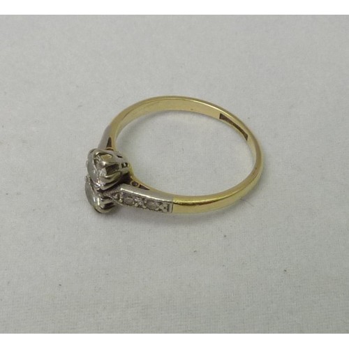 407 - A ring, yellow metal set with two brilliant cut diamonds with four further small diamonds in the sho... 