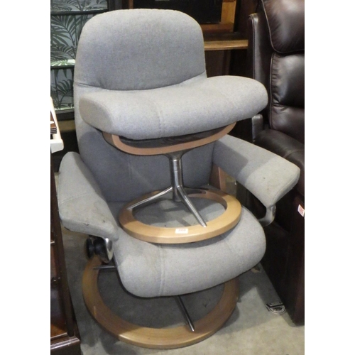 860 - A stressless grey chair and stool af stained.