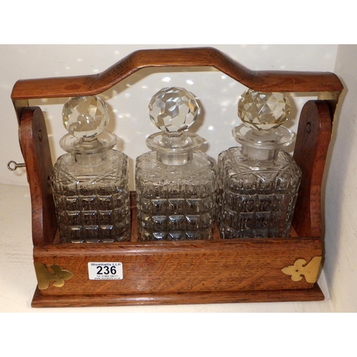 236 - A three bottle oak cased decanter