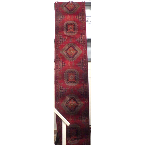 939 - A long machine made red ground stair carpet, wear