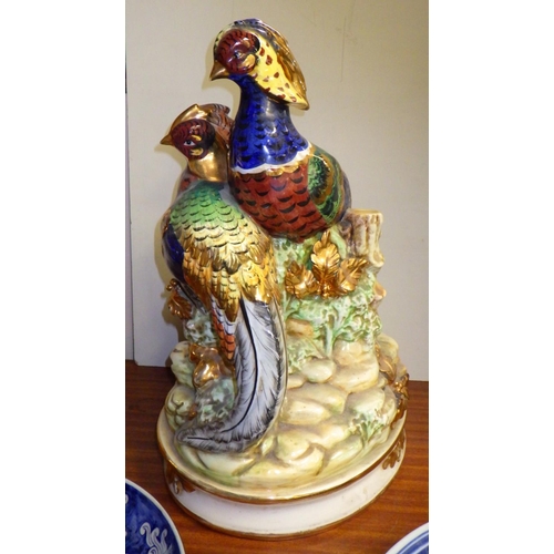 327 - A Pheasant ceramic figure group, 44cm tall; two Chinese chargers.  (3)