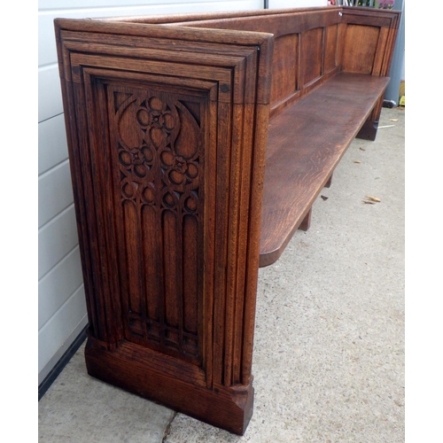 647 - A panelled oak pew, 261cm long, only one end is decorated