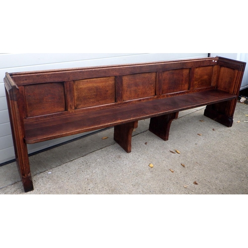 647 - A panelled oak pew, 261cm long, only one end is decorated