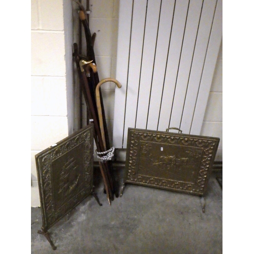 771 - Two brass fire screens together with a group of walking sticks