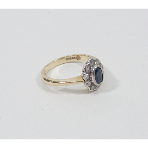 1 - A cluster ring, 18ct gold set with ten brilliant cut white stones around an oval cut blue stone.  Ce... 