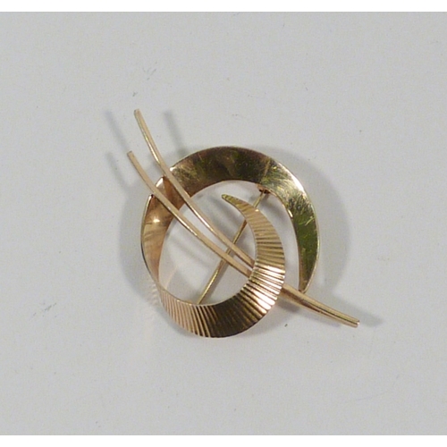 12 - A 9ct gold brooch of ribbon swirl design.  50mm long / 4gr.