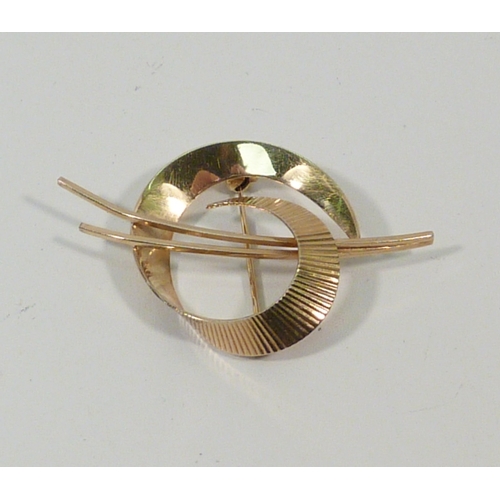 12 - A 9ct gold brooch of ribbon swirl design.  50mm long / 4gr.