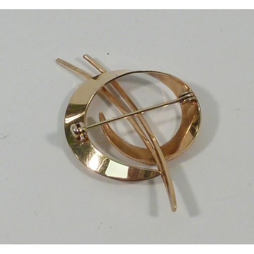 12 - A 9ct gold brooch of ribbon swirl design.  50mm long / 4gr.