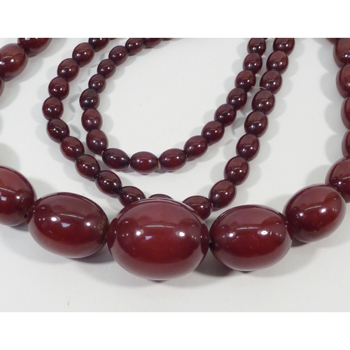 40 - A necklace of graduated cherry amber beads.  940mm long / largest bead 30 x 22mm