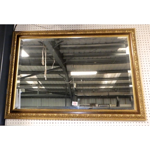 258 - A large framed bevelled mirror 100 x 67 cm together with a further mirror and a floral print (3)