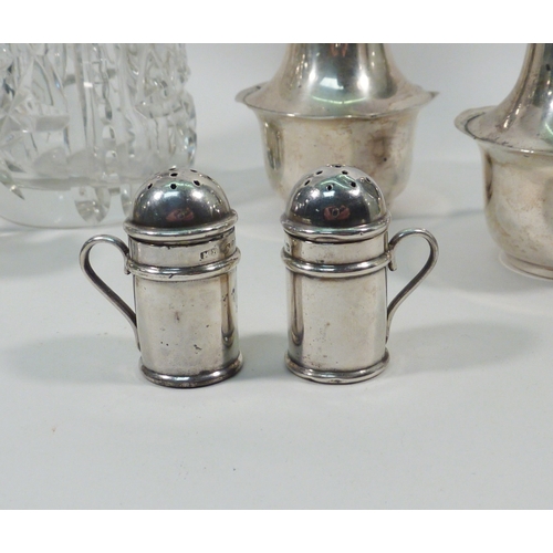 49 - A pair of silver pepper pots; a silver topped cut glass sugar sifter; other silver condiments.