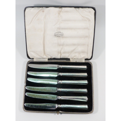 52 - A cased set of six silver bean terminal coffee spoons; two cased sets of six silver handled knives. ... 