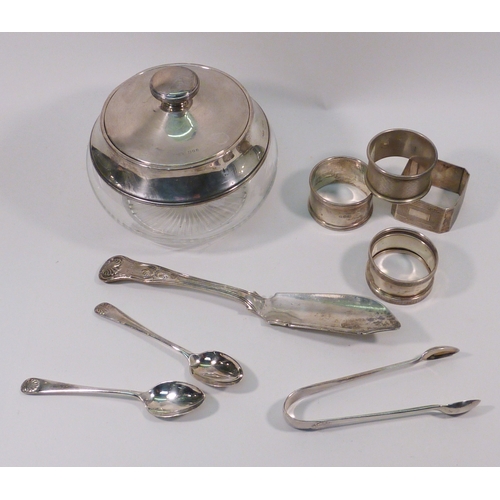 59 - A silver topped glass powder puff jar; four silver napkin rings; a silver master butter knife etc.  ... 