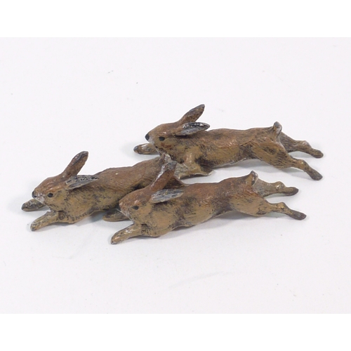 136 - A group of three cold painted bronze running rabbits, unsigned 65mm long; a cold painted bronze rat ... 