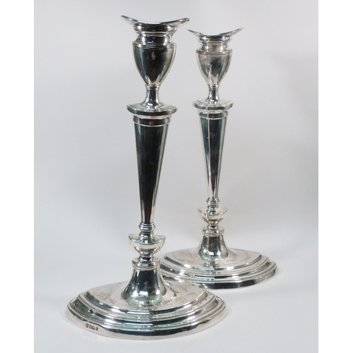 85 - A pair of silver candlesticks, early 20th cent in George III manner, presentation engraving to the b... 