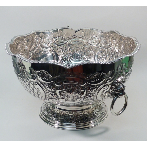 97 - A silver plated pedestal bowl, having two lion head ring handles and repousse decoration.  270mm dia... 