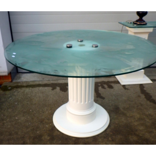 706 - A circular glass topped dining table together with a glass topped side table, top drilled for lamp w... 