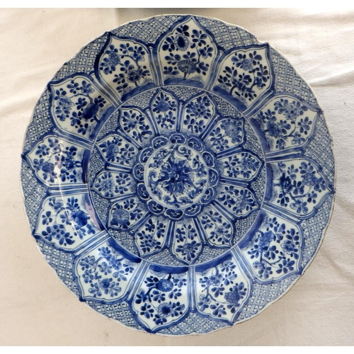 551 - A near pair of Chinese blue and white chargers, profusely decorated with floral panel scheme, the ba... 