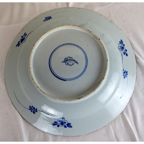 551 - A near pair of Chinese blue and white chargers, profusely decorated with floral panel scheme, the ba... 