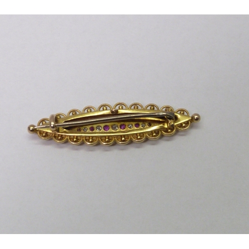 69 - A bar brooch, unmarked yellow metal set with red and white stones.  46mm long