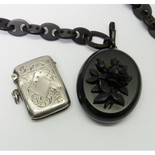 70 - A carved black stone photo locket on a similar graduated chain, a/f small breaks, chain 510mm long /... 