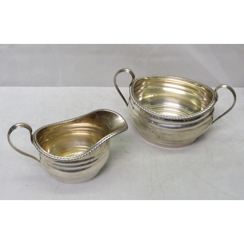 98 - A silver three piece tea set, early 20th cent.  Teapot 282mm long / 860gr gross