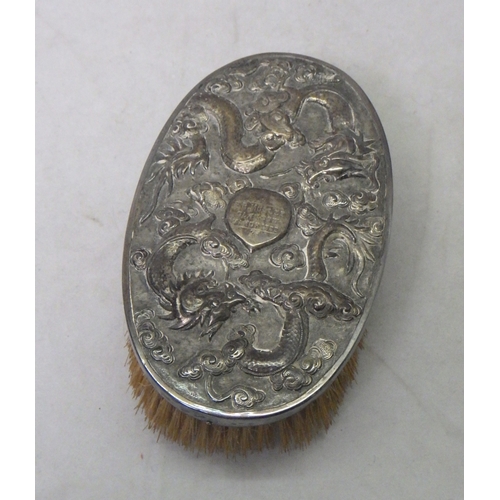 109 - A Chinese white metal hair brush having dragon motif decoration and presentation date 1900; a white ... 