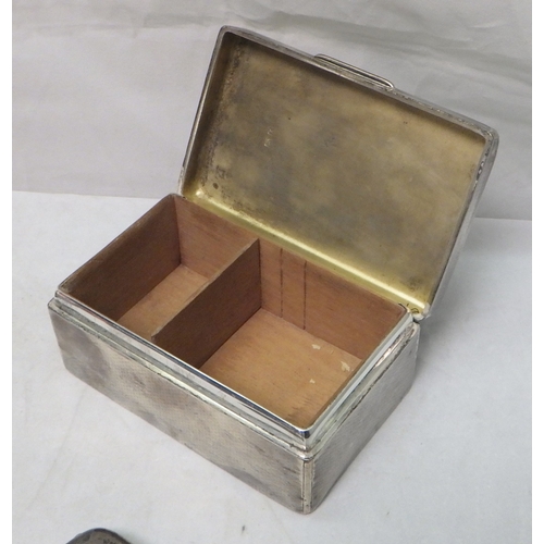 119 - A silver table-standing match box holder, London 1915; a silver cigarette case; a silver cigarette b... 