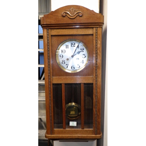 1 - An oak cased striking wall clock 80cm long