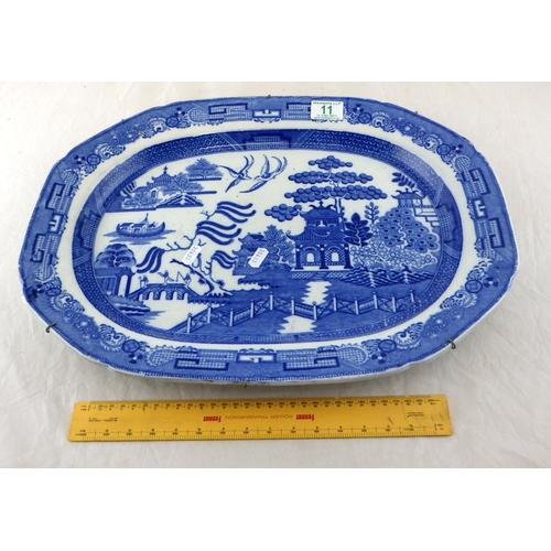 11 - A large 19th C blue and white Willow pattern plate 49 x 37cm