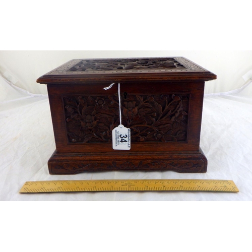 34 - An Oriental motif tea caddy, carved hardwood with a pewter liner.