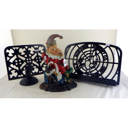 35 - A Mister Punch cast iron doorstop having polychrome decoration; two iron book stands.  (3)