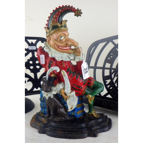 35 - A Mister Punch cast iron doorstop having polychrome decoration; two iron book stands.  (3)