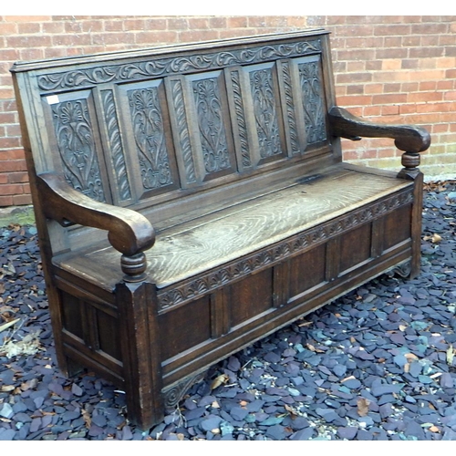 500 - A five panel carved oak settle with box seat, 168cm wide, ex The Retreat (64)