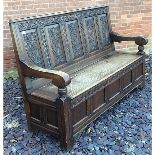 500 - A five panel carved oak settle with box seat, 168cm wide, ex The Retreat (64)