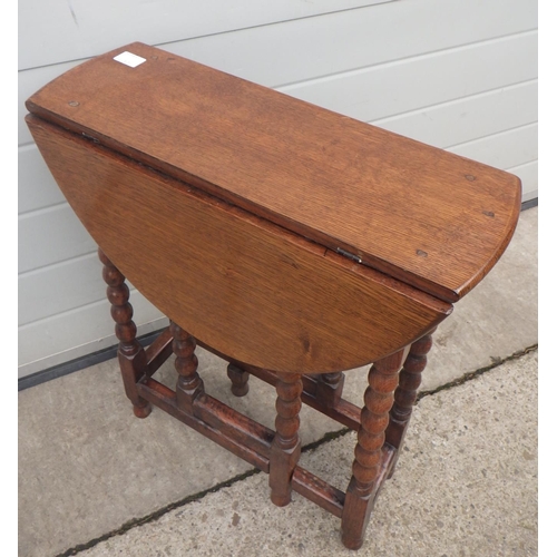 653 - A small bobbin turned oak gateleg table, 60cm across