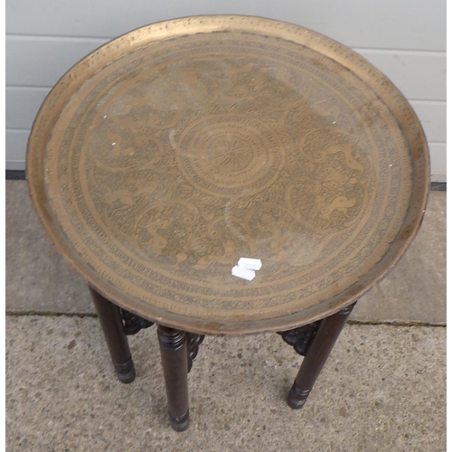 664 - A brass tray topped Benares occasional table on folding base, 49cm across