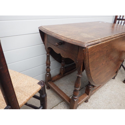 746 - An oak gateleg table with end drawer on turned legs together with four spindle back chairs (5)