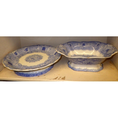 335 - A 19thC willow pattern tureen together with a blue and white pedestal plate and serving dish (3)